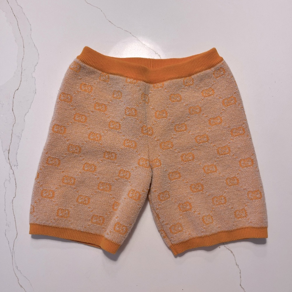 Toddlers' orange Gucci wool knit shorts with GG pattern throughout.